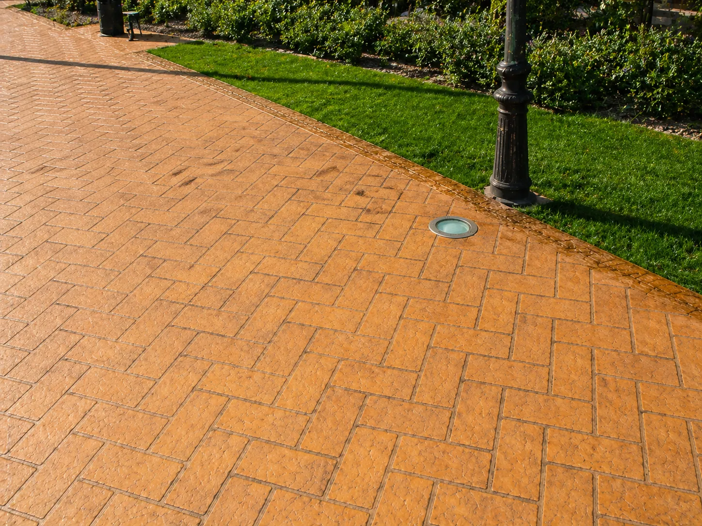 Vorera urbana amb paviment de formigó decoratiu i lluminària empotrada — ús típic en zones peatonals i espais públics